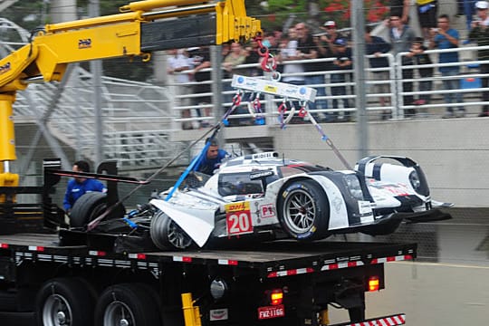 Mark Webbers völlig demolierter Porsche wird nach dem Unfall von der Strecke transportiert.