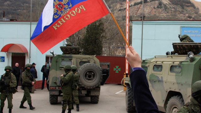 Eine Frau mit russischer Flagge an der Grenze zur Krim.