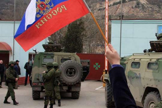 Eine Frau mit russischer Flagge an der Grenze zur Krim.