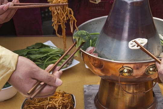 Chinesisches Fondue funktioniert wie klassisches Fondue mit Öl: Sie garen verschiedene Zutaten in einer leckeren Brühe.