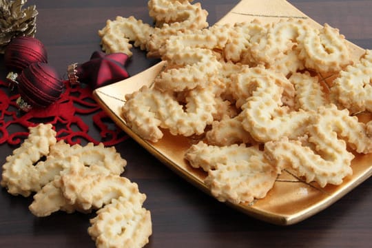 Die fertigen Plätzchen können Sie mit Schokolade überziehen oder mit Zuckerguss und Zuckerperlen verzieren