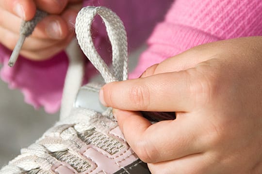 Eine Schleife zu binden, dauert länger als einen Klettverschluss zu schließen. Doch Eltern sollten sich und ihren Kindern diese Zeit gönnen.