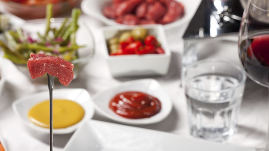 Fondue: Beim Umgang mit rohem Fonduefleisch sollten Sie vorsichtig sein. Sonst drohen Salmonellen.