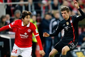 Der Mainzer Joo-Ho Park (li.) wird von Bayern-Profi Thomas Müller unter Druck gesetzt.