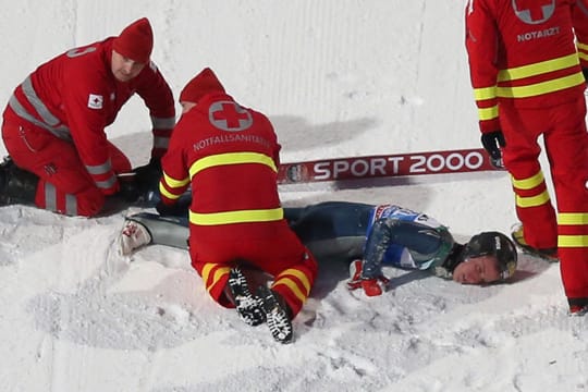 Nach seinem schweren Sturz in der Qualifikation von Bischofshofen wird Nicholas Fairall von Sanitätern versorgt.