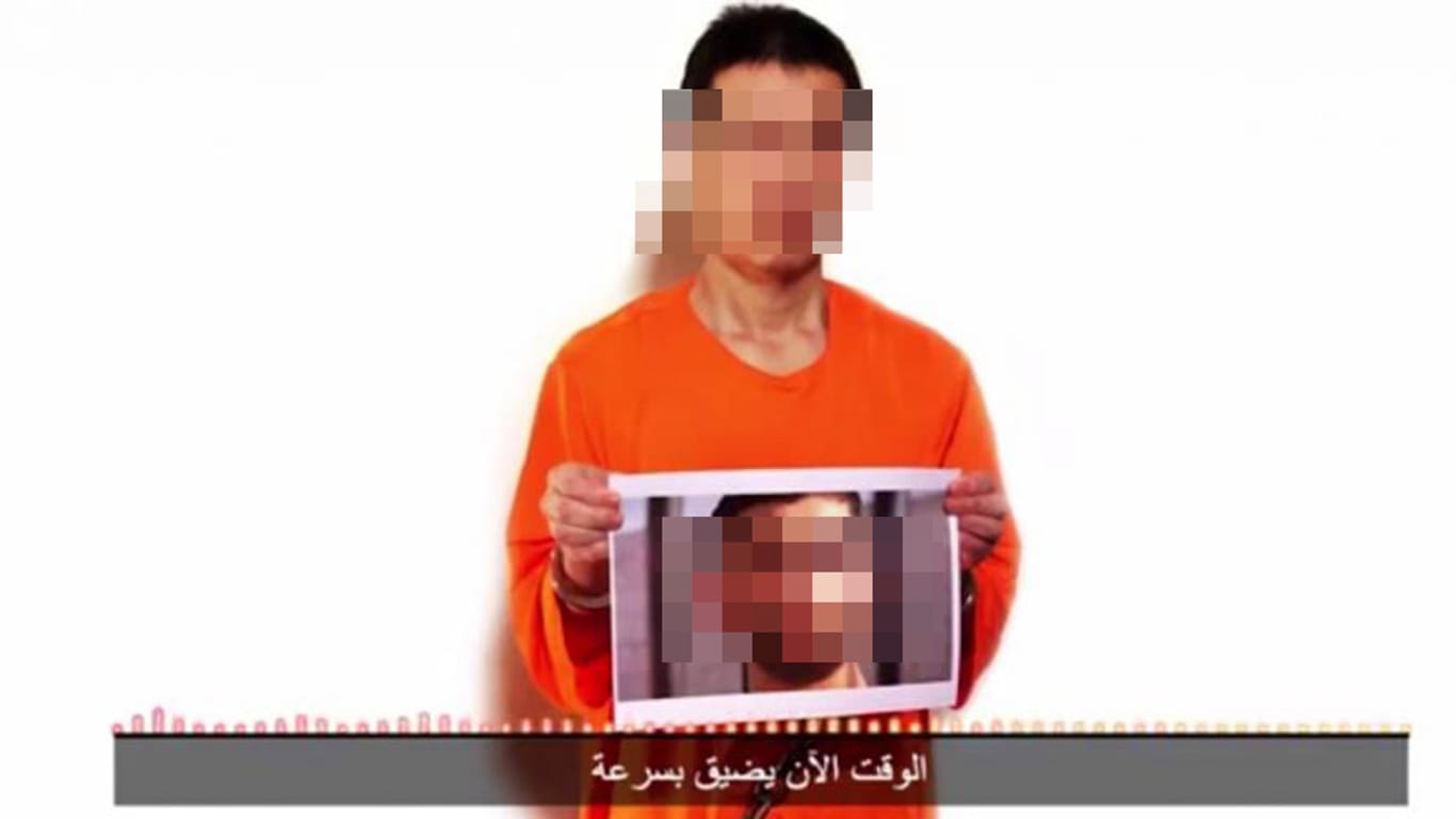 Screenshot aus einem IS-Internetvideo: Die japanische Geisel Kenji Gote zeigt ein Foto des ebenfalls entführten jordanischen Piloten