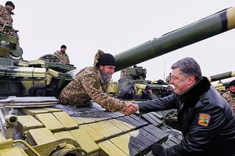 Der ukrainische Präsident Petro Poroschenko begrüßt eine Panzerbesatzung auf einem Stützpunk in Charkiw.