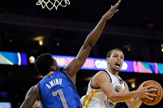 Steph Curry (re.) zieht an Al-Farouq Aminu von Mavs vorbei.