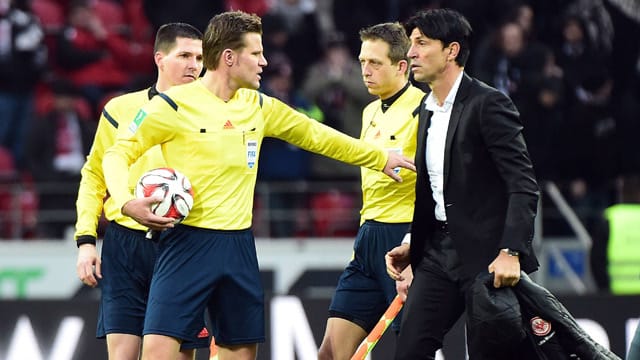 Nach dem Abpfiff in Mainz muss Schiedsrichter Felix Brych (2.v.li.) Frankfurts Sportdirektor Bruno Hübner beruhigen.