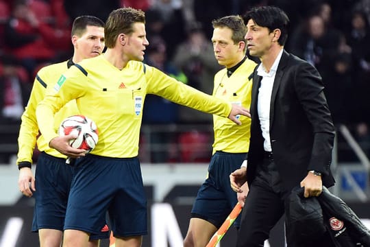 Nach dem Abpfiff in Mainz muss Schiedsrichter Felix Brych (2.v.li.) Frankfurts Sportdirektor Bruno Hübner beruhigen.