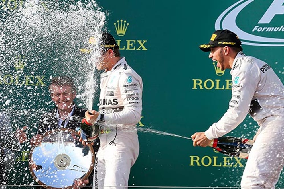 Erst im Rennen, dann bei der Sektdusche: Lewis Hamilton macht Mercedes-Rivale Nico Rosberg nass.