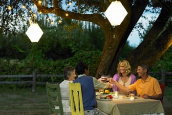 Mit Laternen, Lichterketten und bunten Möbeln lassen sich gemütliche Sommerabende im Garten verbringen.