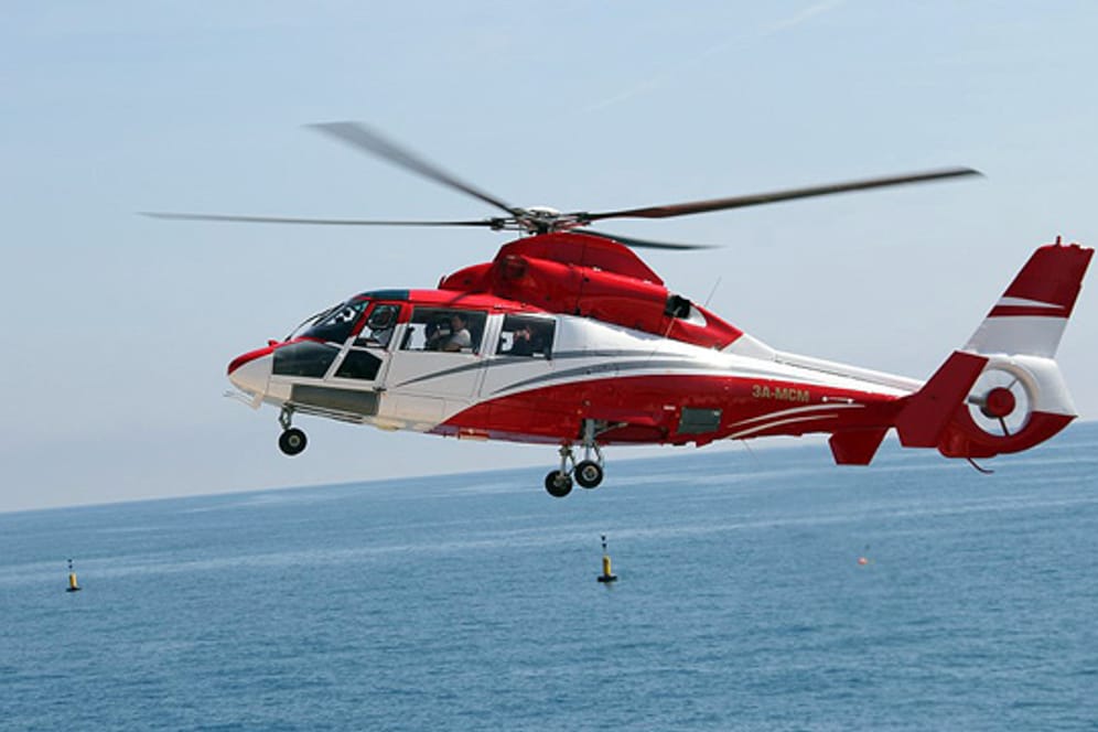 Ein Eurocopter Dauphin AS 365 N der Heli Air Monaco beim Flug über das Meer.
