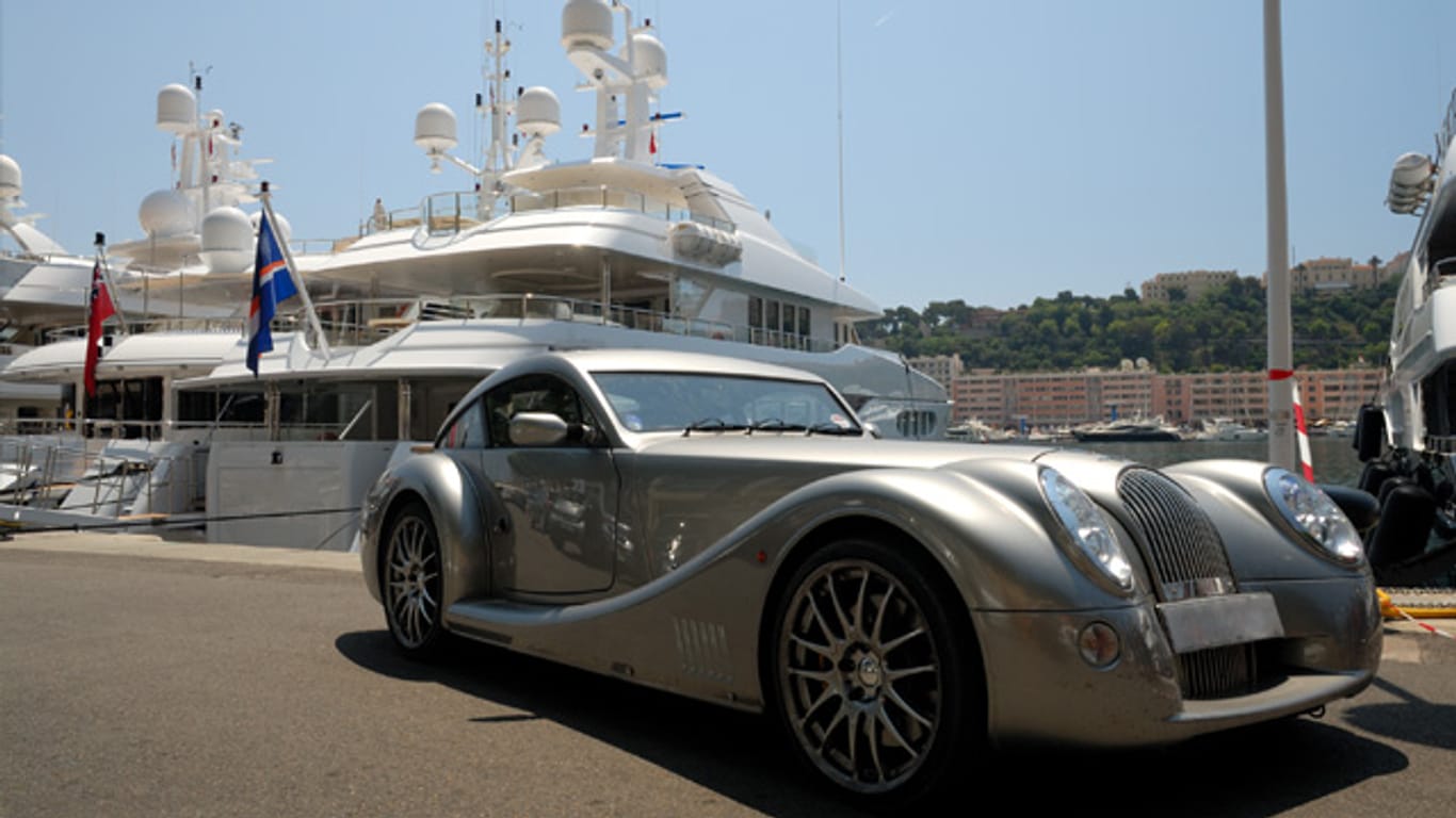 Ein Traumauto wartet vor einer Jacht in Monaco.
