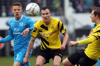 Dortmunds Weltmeister Kevin Großkreutz (re.) und Bentley Baxter Bahn von den Stuttgarter Kickers verfolgen gespannt die Flugkurve des Balles.