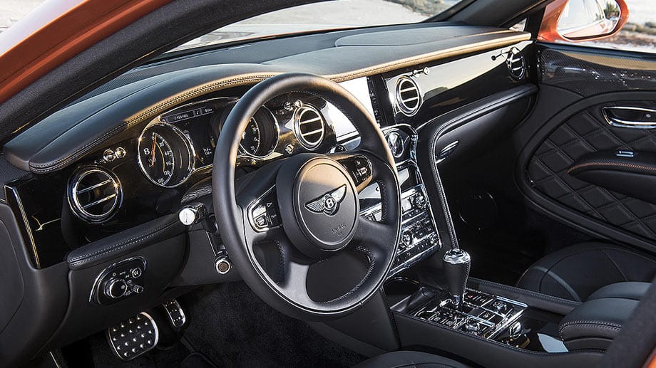 Im Bentley nimmt man(n) traditionell gerne auf dem Fahrersitz Platz. Die klassischen Instrumente werden diskret von digitalen Anzeigen ergänzt. Das moderne Infotainment-System mit hervor gleitendem Display lässt sich mit einem 2200 Watt starken Soundsystem von Naim kombinieren.