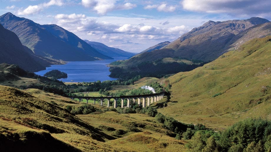 Bezaubernde Landschaft am Glenfinnan-Viadukt: die schottischen Highlands erleben Touristen auf der Zugfahrt in ihrer rauen Schönheit.