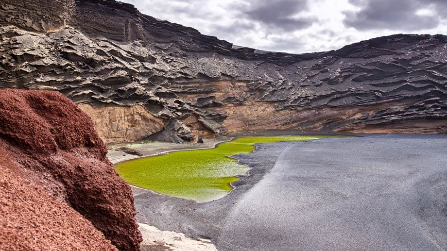 Der „Lago Verde“ auf Lanzarote fällt durch seine grellgrüne Färbung auf. Und ist damit ein Highlight der kanarischen Insel vulkanischen Ursprungs.