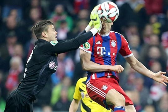 Mitch Langerak (li.) trifft Robert Lewandowski mit voller Wucht.