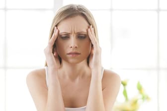 Kopfschmerzen bei Frauen sind häufig hormonell bedingt und treten vor oder während der Periode auf.