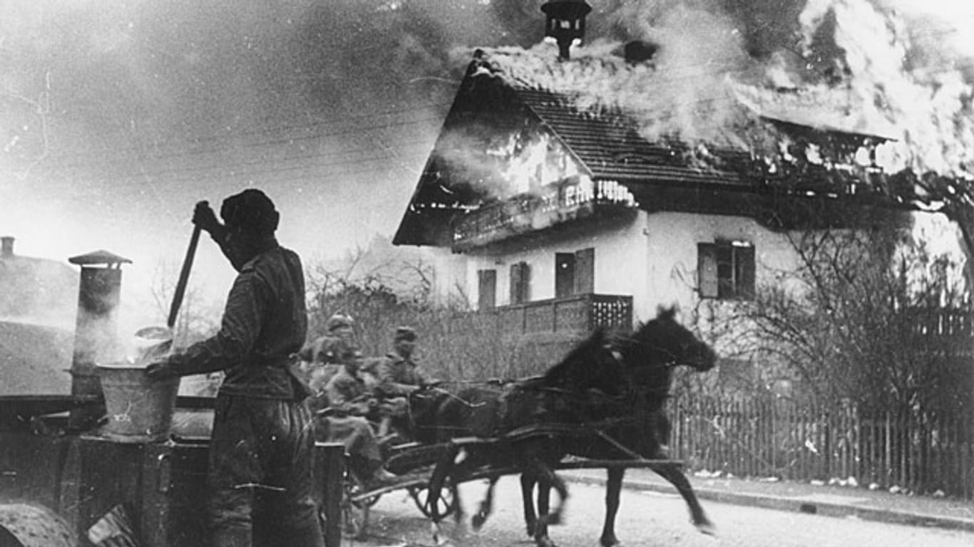 Russischer Vormarsch nahe Wien: Eine Kutsche mit Rotarmisten prescht zwischen einer fahrbaren Suppenküche und einem brennenden Haus hindurch.