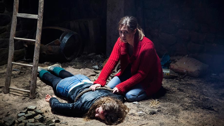Jule Sanders (Charleen Deetz, l.) und Miranda Kador (Emily Cox) kommen in einem dunkeln Kellerloch wieder zu sich.