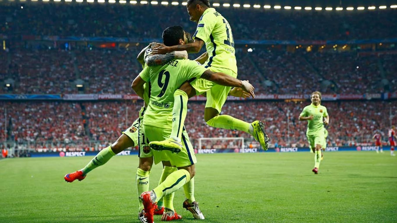 Lionel Messi (hinten), Luis Suarez und Neymar (re.) bejubeln einen der zwei Treffer für Barcelona in München.