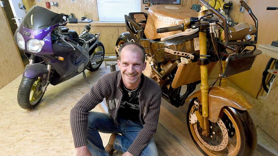 Andre Schlosser zwischen seinem Motorrad aus Holz, das er in den vergangenen zwölf Jahren gebaut hat und seiner "richtigen" Maschine, einer Yamaha FZR 600R Aral Cup.