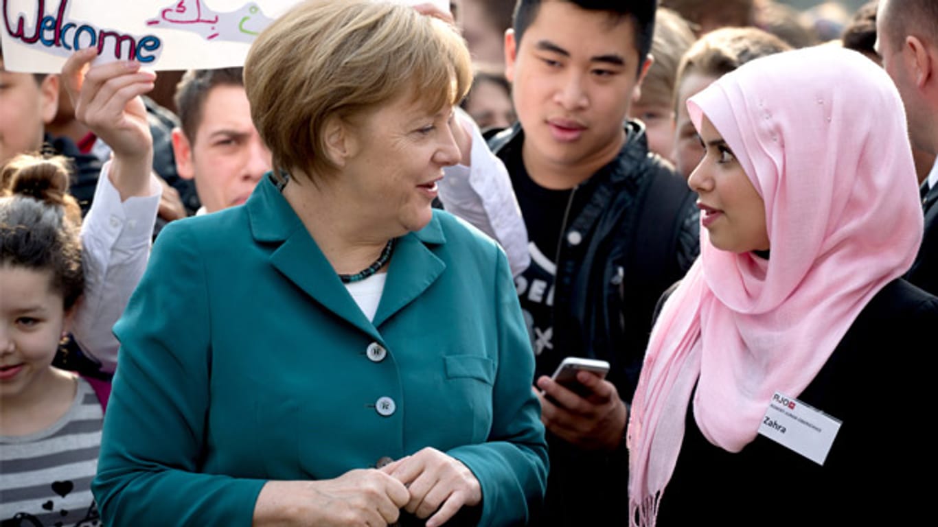 Definitionsfrage: Wie hält es Deutschland mit seinem Einwohnern mit Migrationshintergrund? Bundeskanzlerin Angela Merkel 2014 bei einem Besuch der Staatlichen Europaschule in Berlin Wilmersdorf.