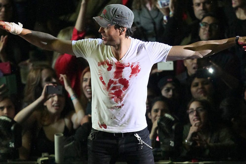 Mit Herzblut bei der Sache: Enrique Iglesias hat sich nach dem Unfall mit seiner blutigen Hand ein Herz aufs weiße T-Shirt gemalt.