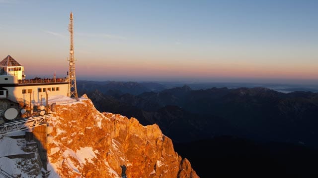 Die aufgehende Sonne taucht die Zugspitze in unterschiedlichste Farben.