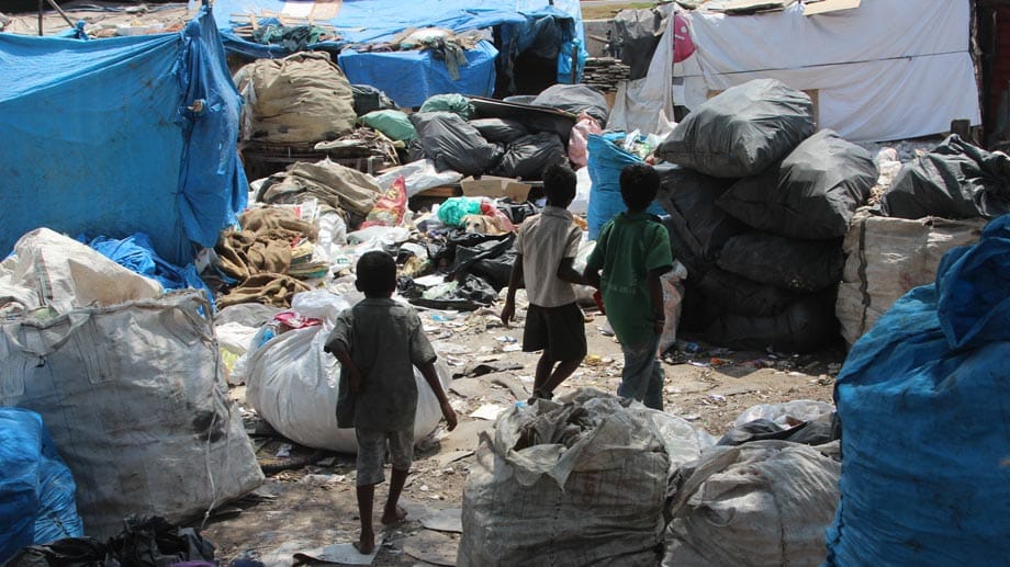 Giftige Dämpfe, ekliger Abfall - Müllberge sind die Arbeitsstätte der Müllsammler Raju (9), Vamshi (13) und Lalu (13). Sie laufen durch ihren Slum in der Hitec City in Hyderabad, Indien, und sortieren Abfall.