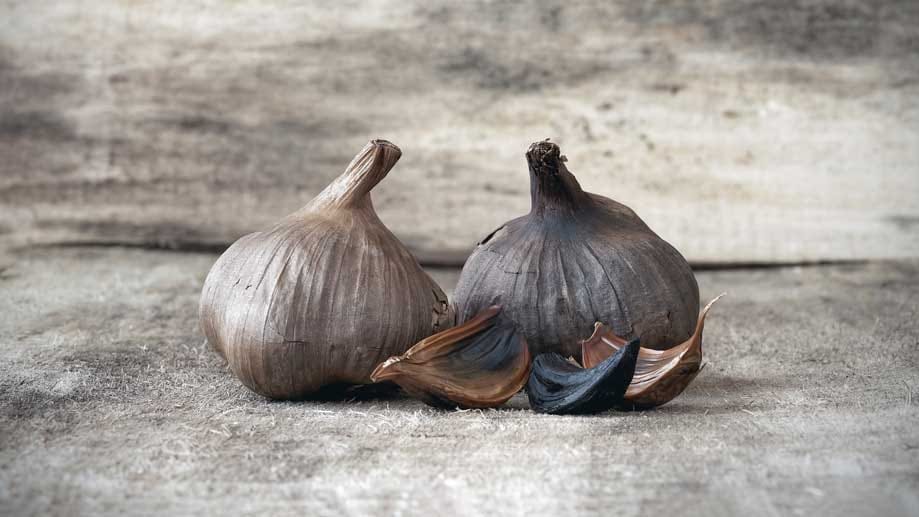 Schwarzer Knoblauch sieht spannend auf dem Teller aus und schmeckt mild-süßlich ohne Schärfe, aber mit Noten nach Rauch und Lakritz. Er entsteht durch die Fermentierung junger Knollen bei mäßig hoher Temperatur und intensiver Luftfeuchtigkeit. Das dauert etwa zwei Monate. In China und Asien ist schwarzer Knoblauch eine uralte Zutat, nun ist sie auch hier im Trend.