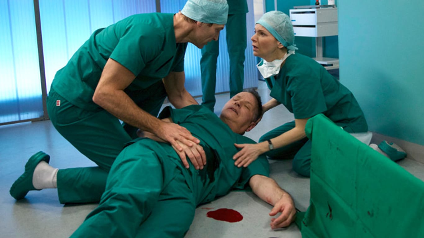 Dr. Heilmann (Thomas Rühmann, Mitte) fällt einer Messerattacke zum Opfer. Wird er überleben?