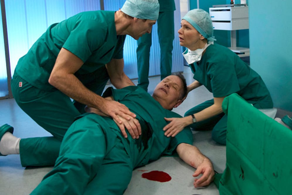Dr. Heilmann (Thomas Rühmann, Mitte) fällt einer Messerattacke zum Opfer. Wird er überleben?