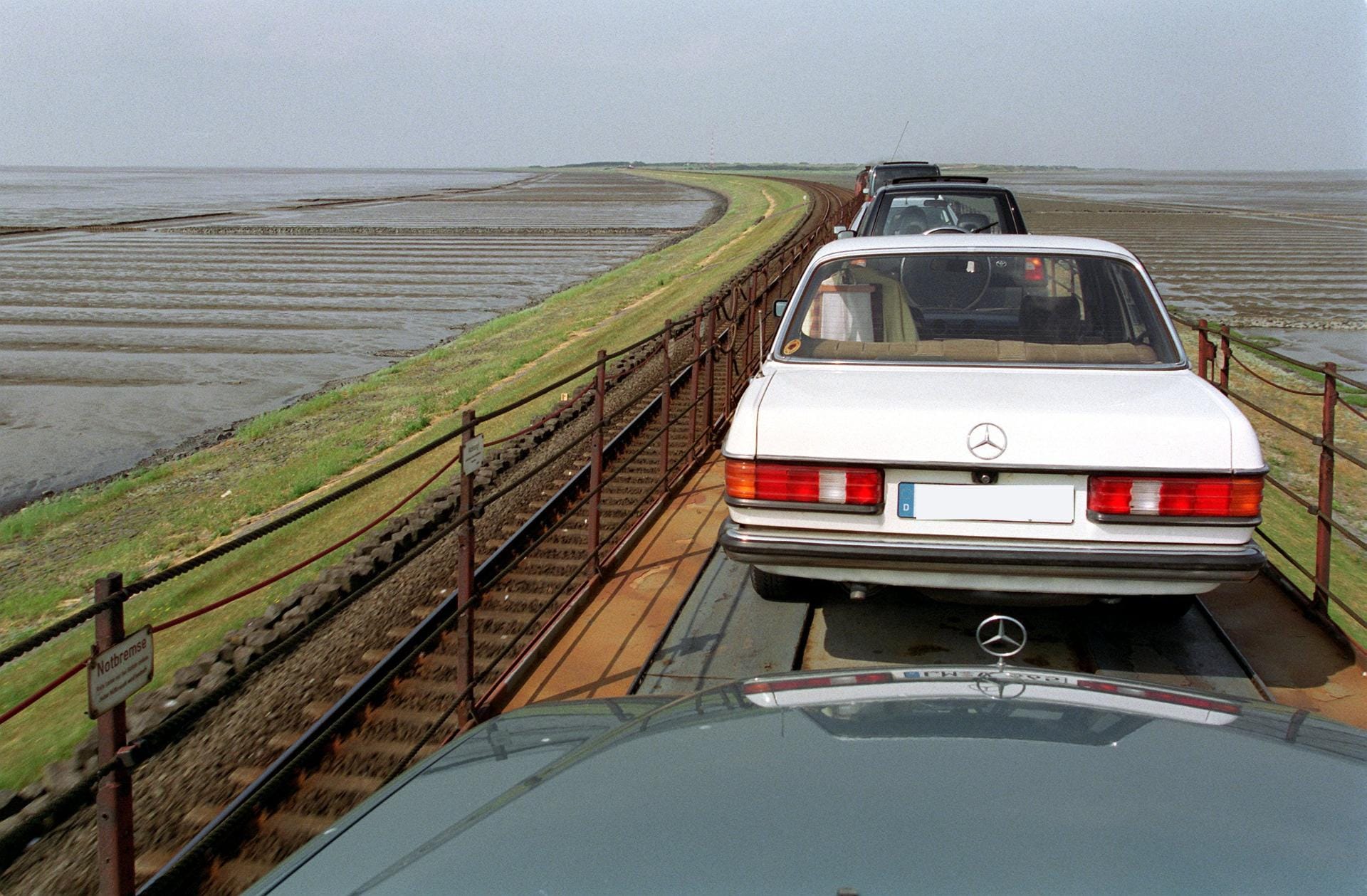 Dieser Autoreisezug fährt 1995 über den Hindenburgdamm. Der 11,2 Kilometer lange Eisenbahndamm verbindet die Nordsee-Insel Sylt mit dem Festland von Schleswig-Holstein.