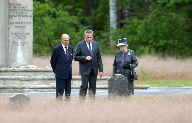 Königin Elizabeth II. und Prinz Philip stehen neben Jens-Christian Wagner, dem Direktor der KZ-Gedenkstätte Bergen-Belsen in Niedersachsen.