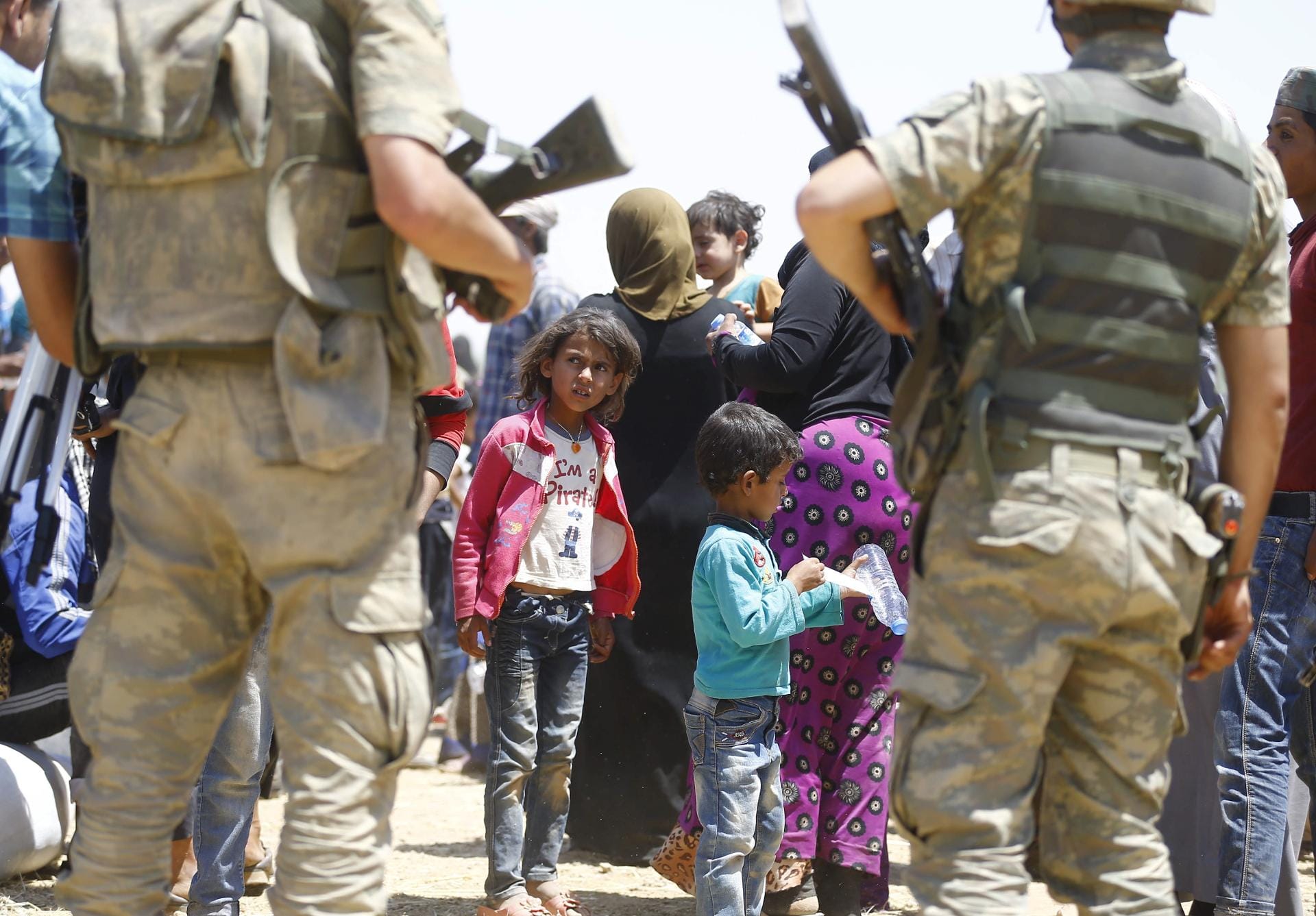 Türkische Soldaten bewachen den Grenzübergang, während die Flüchtlinge darauf warten, eingelassen zu werden. Türkische Soldaten bewachen den Grenzübergang, während die Flüchtlinge darauf warten, eingelassen zu werden.