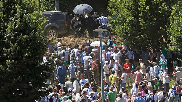 Sicherheitskräfte begleiten den fliehenden serbischen Ministerpräsidenten zum Auto.