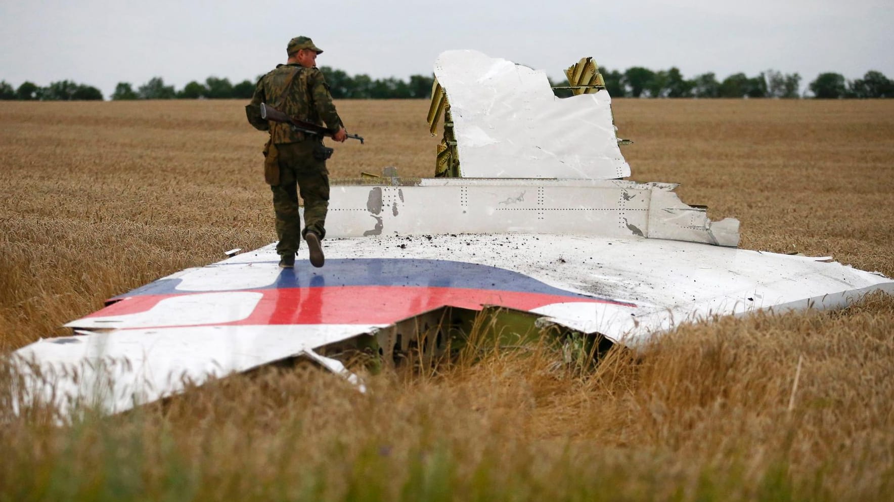 Ein prorussischer Separatist steht vor Trümmerteilen der Boeing 777 der Malaysian Airlines, die über der Ostukraine abgeschossen wurde.