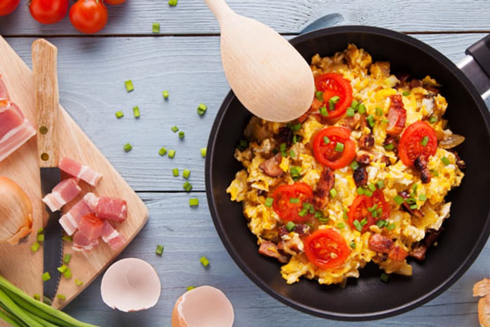 Herzhaftes Frühstück: Rührei mit Speck, frischen Tomaten und Kräutern passt in das Konzept der Paleo-Diät.