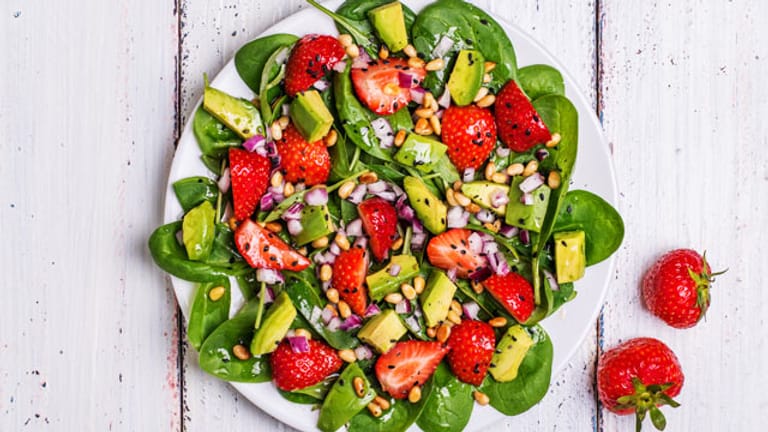 Ein Salat aus Blattspinat, Erdbeeren und Avocado passt gut in die Paleo-Diät.