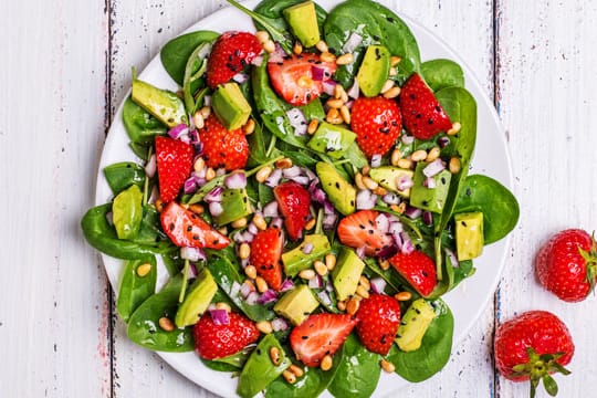 Ein Salat aus Blattspinat, Erdbeeren und Avocado passt gut in die Paleo-Diät.