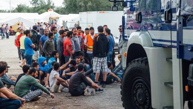 Flüchtlinge versammeln sich am Eingang des Aufnahmelagers an der Bremer Straße in Dresden.