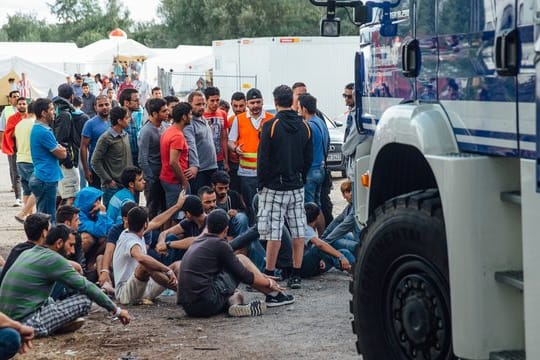 Flüchtlinge versammeln sich am Eingang des Aufnahmelagers an der Bremer Straße in Dresden.