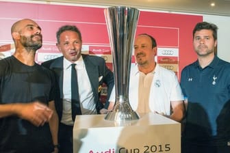 Bayern-Coach Guardiola (l-r), Milan-Trainer Mihajlovic, Real Madrids Trainer Benítez und der Trainer von Tottenham, Pochettino, stehen um den Audi Cup herum.