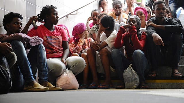 Flüchtlinge aus verschiedenen Ländern warten am Bahnhof in Rosenheim (Bayern) auf ihre Registrierung.