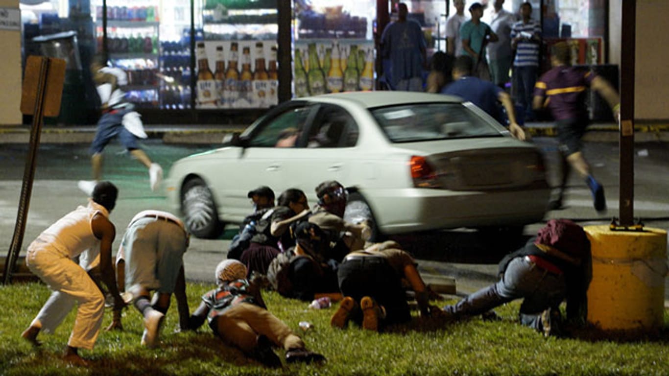 Demonstranten bringen sich in Ferguson in Sicherheit, nachdem Schüsse gefallen waren.