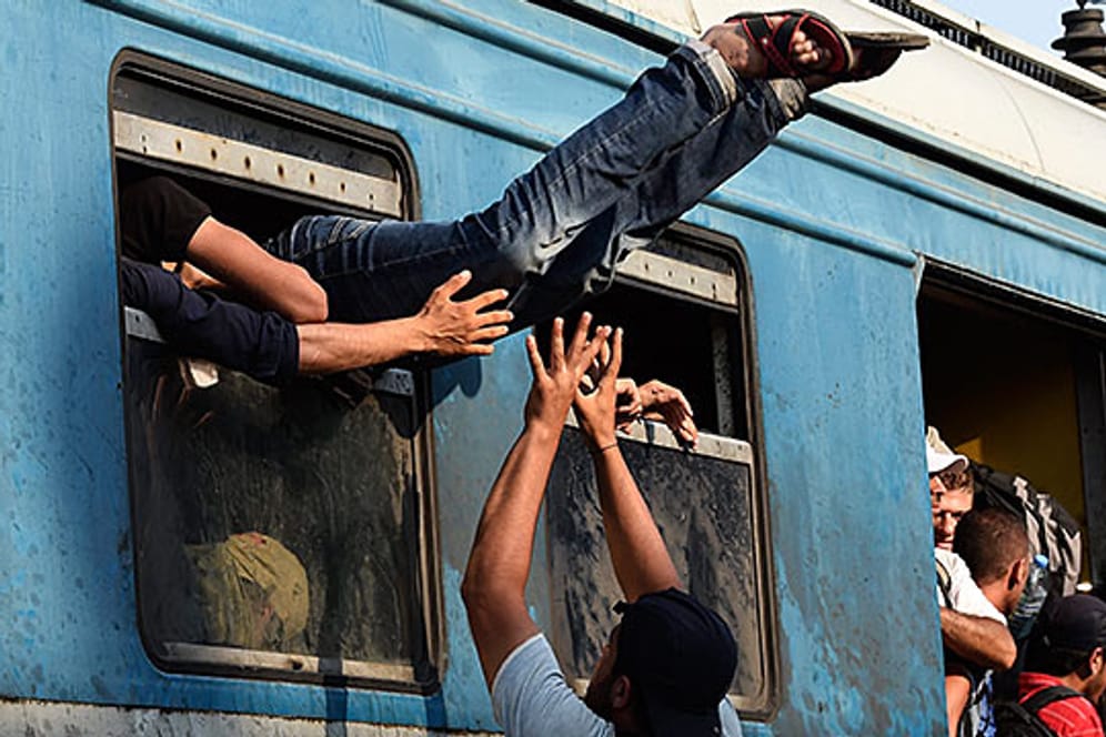 Flüchtlinge stürmen in Mazedonien einen Zug nach Serbien.