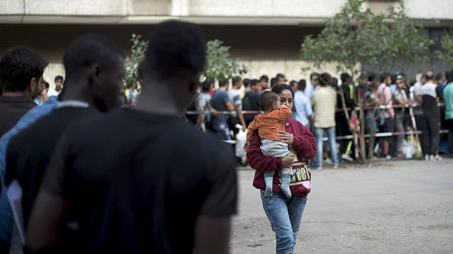 Menschen warten vor einem Sozialamt in Berlin: In Deutschland werden sie angesichts ihrer Menge zu Zahlen, die Kopfzerbrechen bereiten.